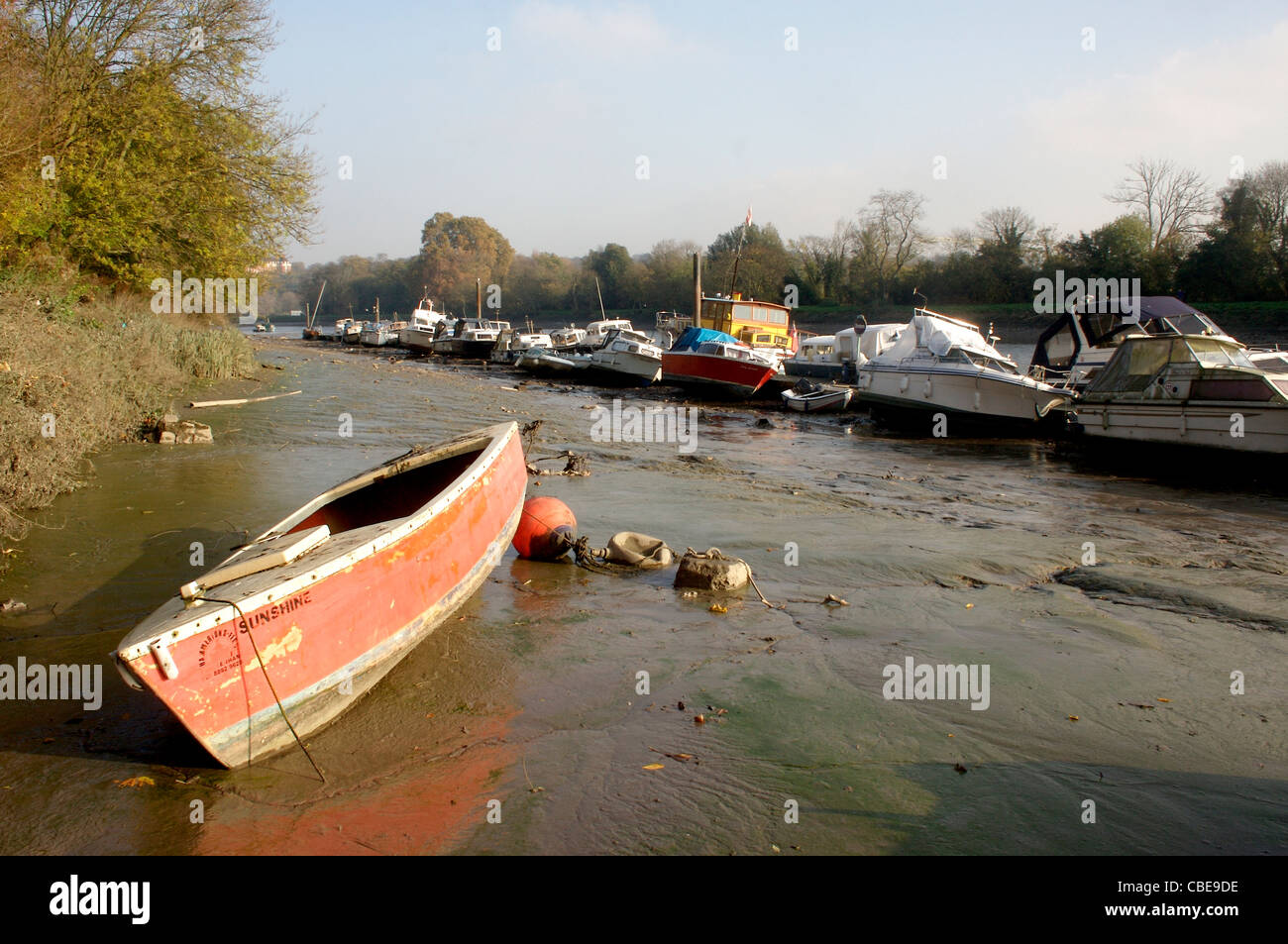 a small boat sits in very low tide along the River Thames in Richmond Upon Thames, London, England Stock Photo