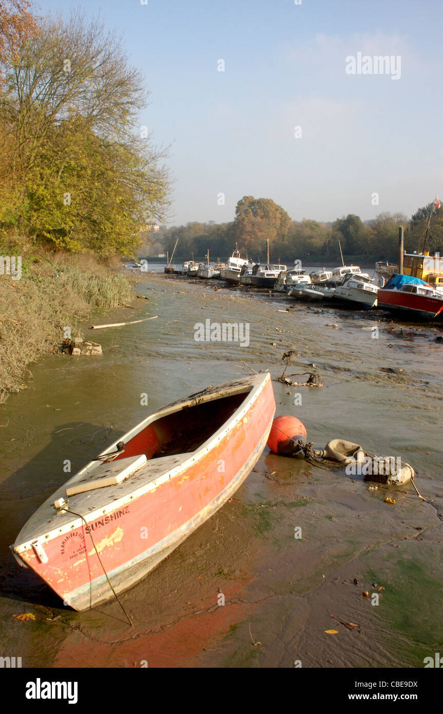 a small boat sits in very low tide along the River Thames in Richmond Upon Thames, London, England Stock Photo