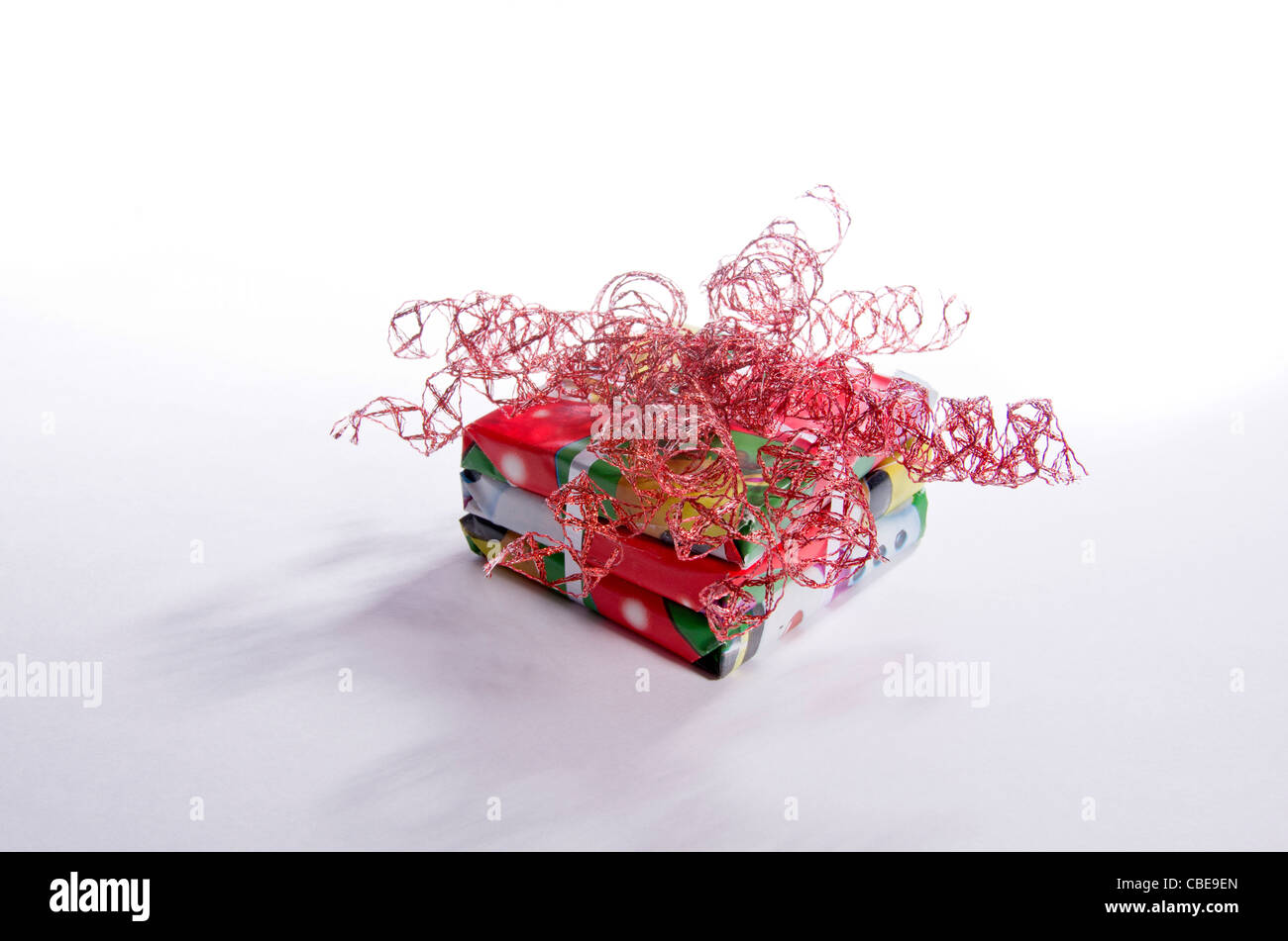 A pile of square Christmas presents wrapped in festive red paper with a ...