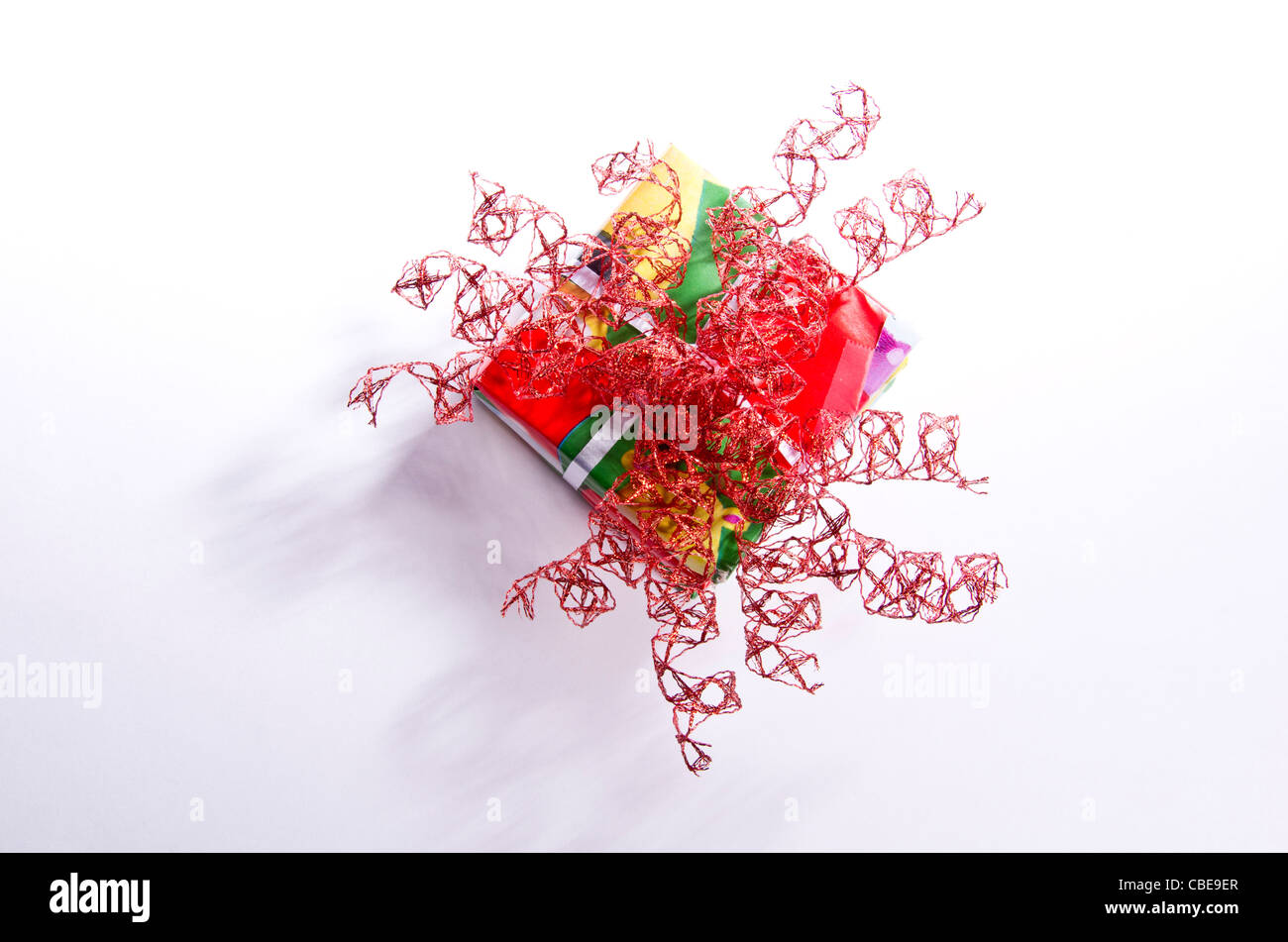 A pile of square Christmas presents wrapped in festive red paper with a ...