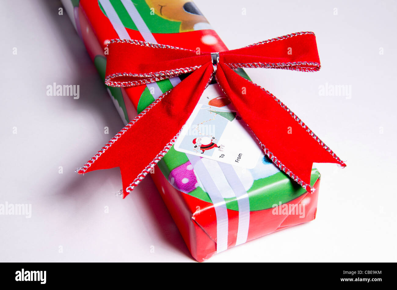 A Christmas gift with white ribbon, red bow and gift tag sticker Stock