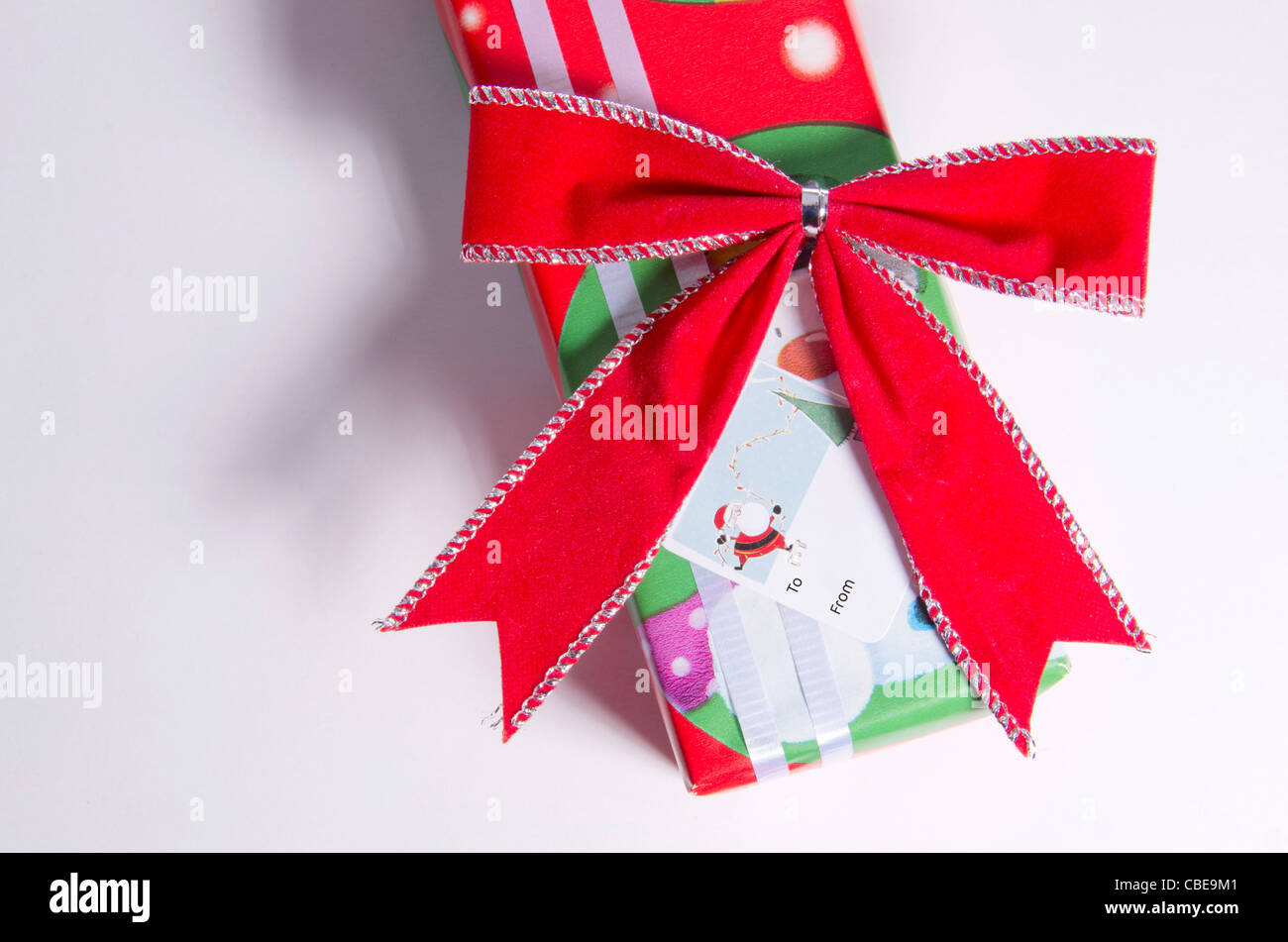 A Christmas gift with white ribbon, red bow and gift tag sticker Stock