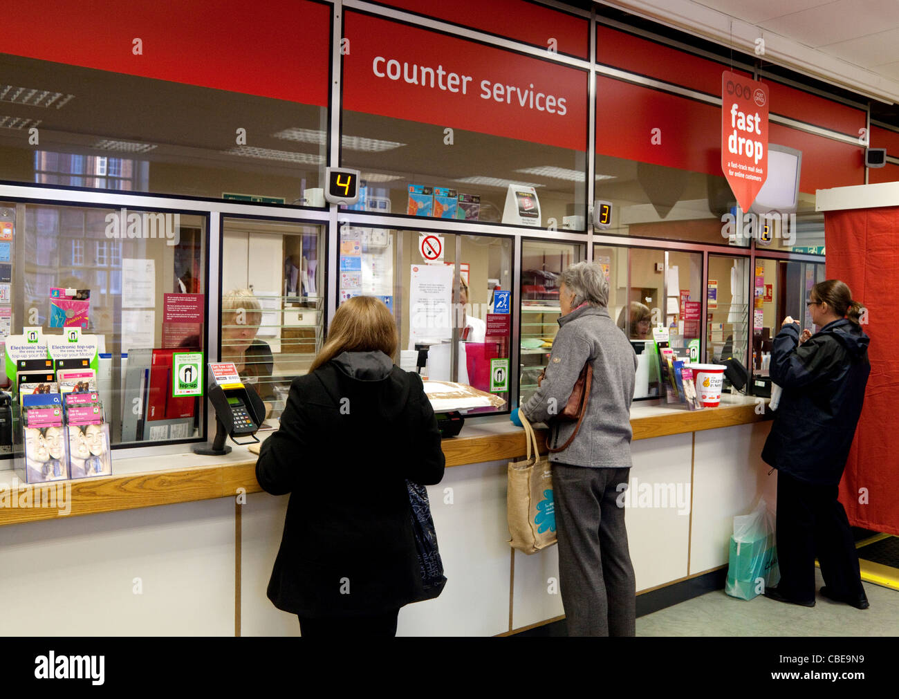 Post Office counter UK; People at the counter inside an English Post Office, Suffolk UK Stock Photo