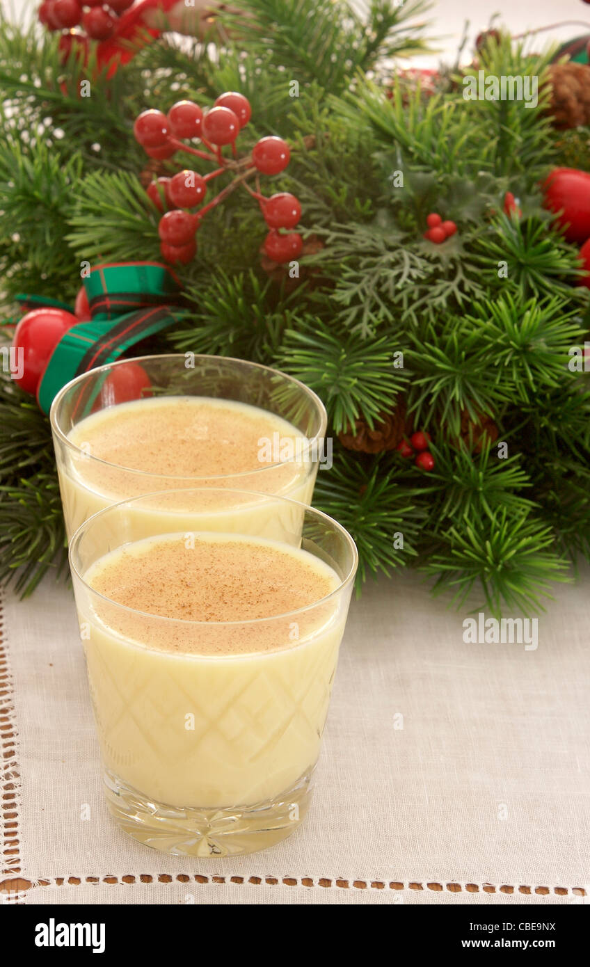 Two glasses of eggnog garnished with nutmeg lined up in front of a ...