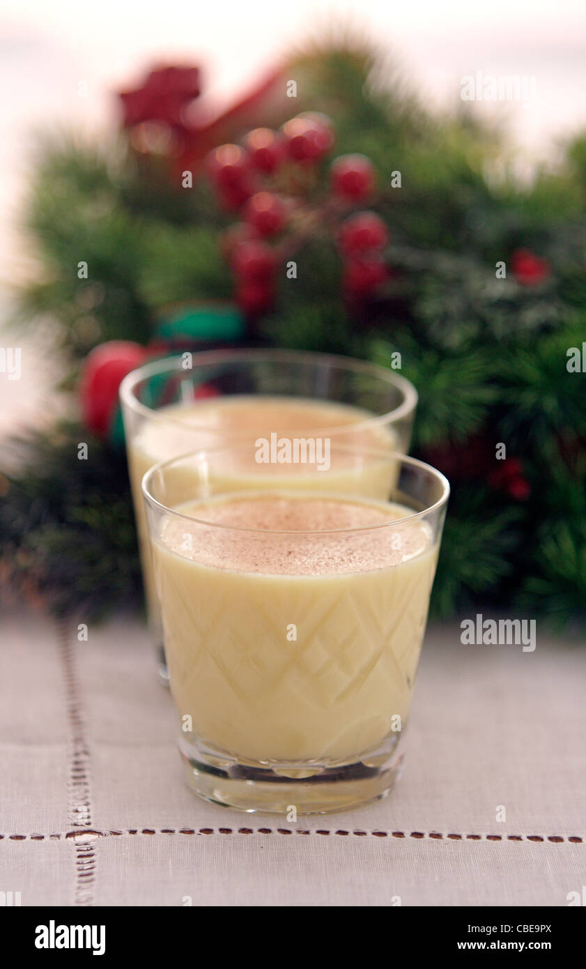 Two glasses of eggnog garnished with nutmeg lined up in front of a ...