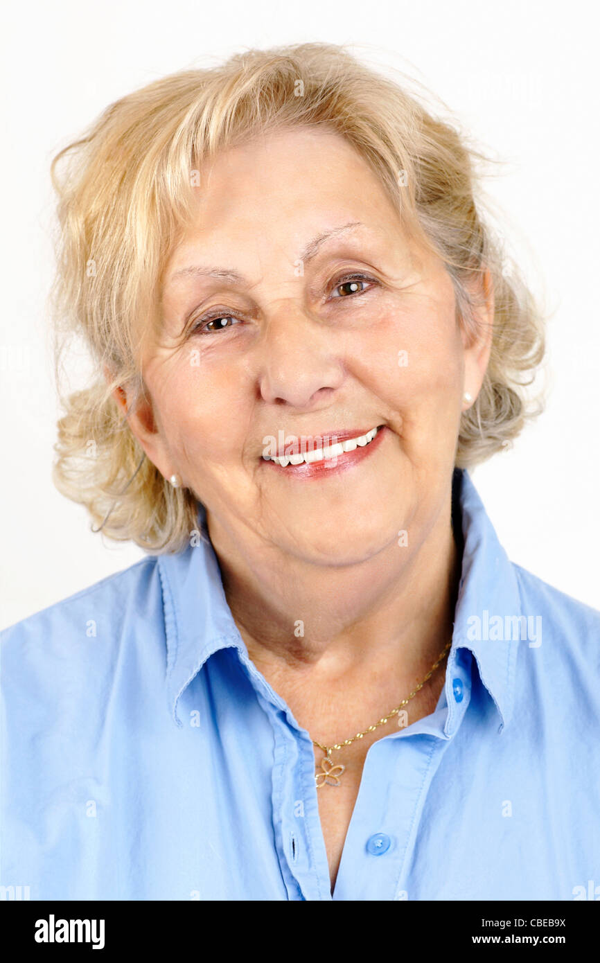 Portrait of a happy, beautiful and healthy senior woman wearing a blue shirt, isolated on white. Stock Photo