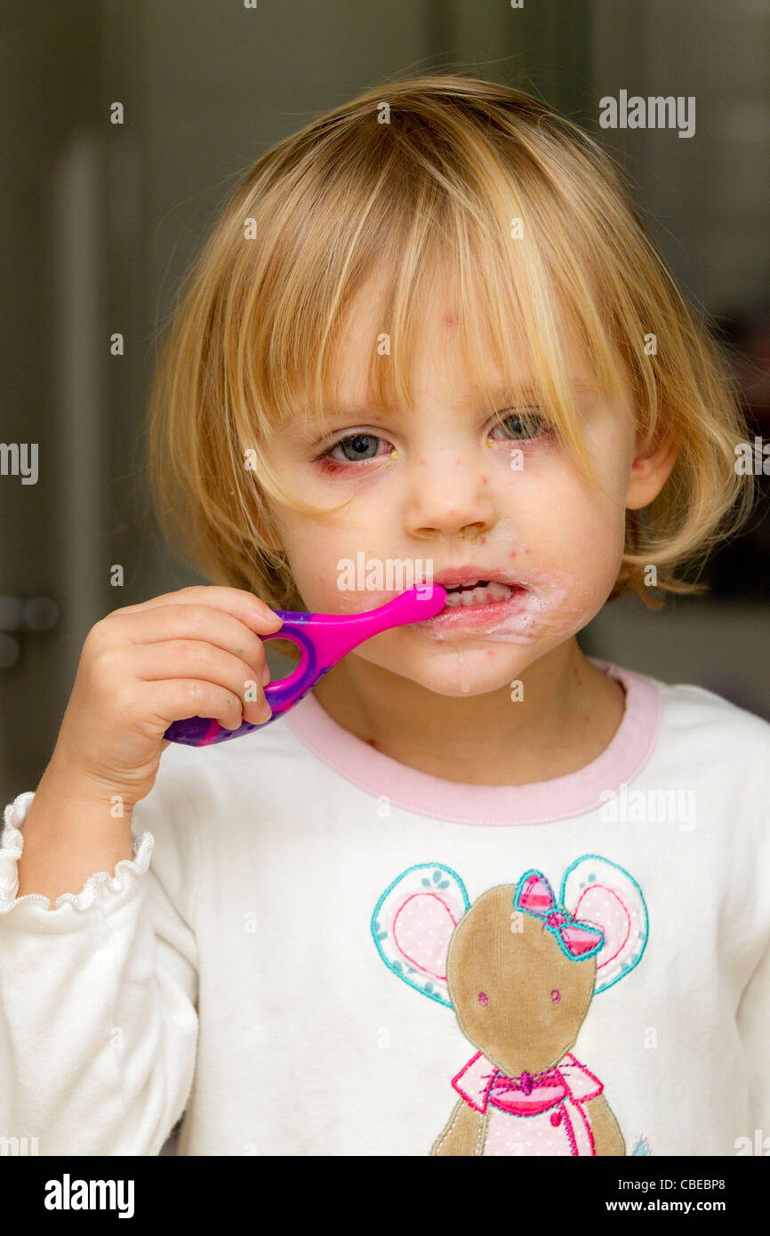 Sad-looking little girl with chicken pox cleaning her teeth. Stock Photo