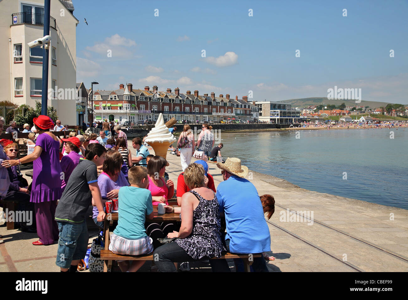 Visitors relaxing at a waterfront cafe in the popular south coast resort of Swanage Stock Photo