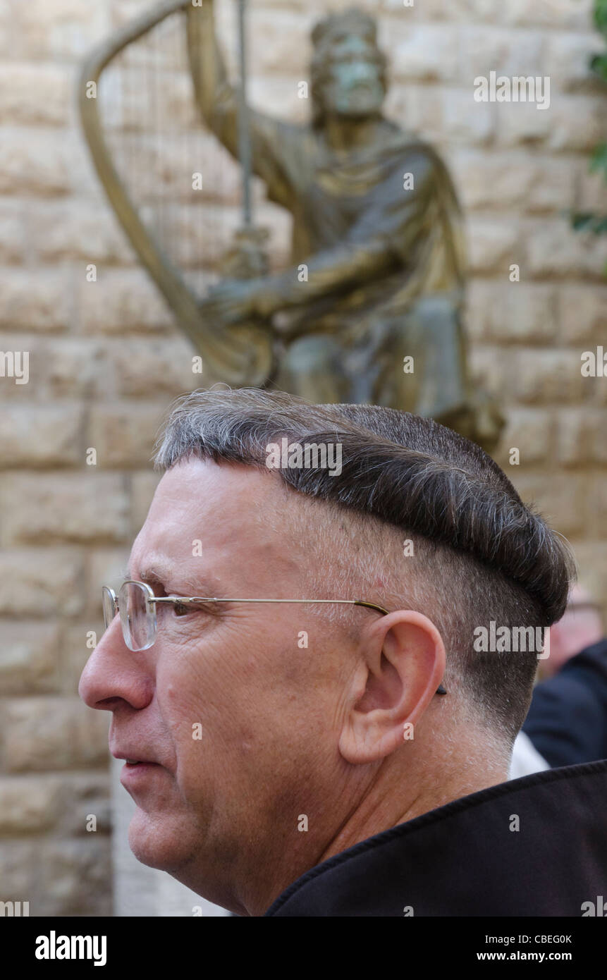 portrait of a priest with haircut and statue of King David in bkgd