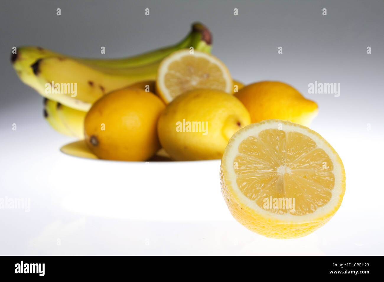 United Kingdom. Studio. Still life image of a fruit bowl, focusing on a half cut lemon. 2011 Stock Photo