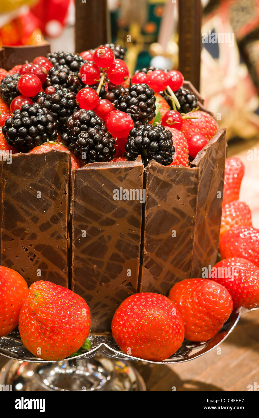 A Christmas cake piled high and surrounded by delicious fruit bordered by chocolate segments. Stock Photo
