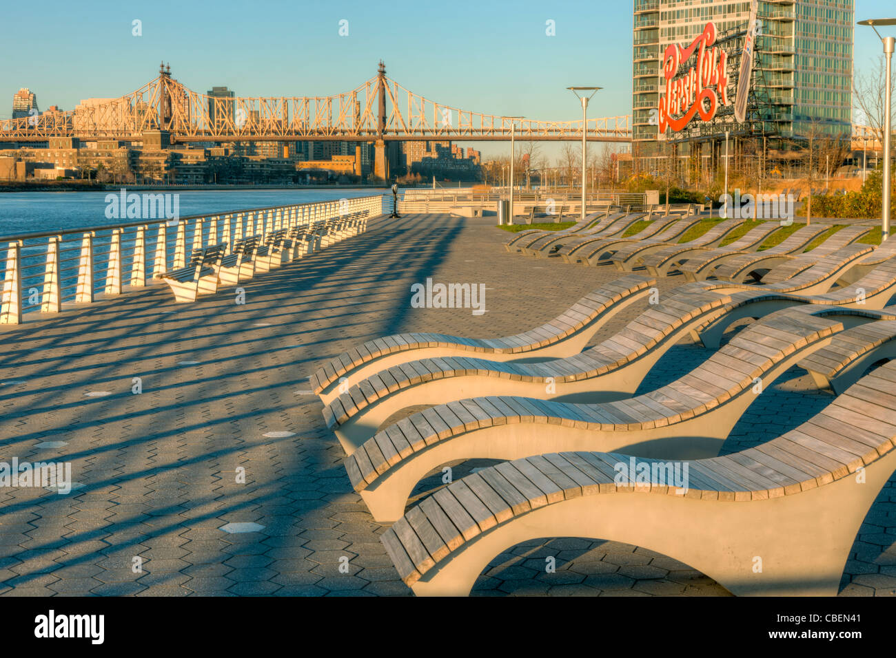 Seating with views of Manhatan and the historic Pepsi-Cola sign in Gantry Plaza State Park in Long Island City, Queens, New York. Stock Photo