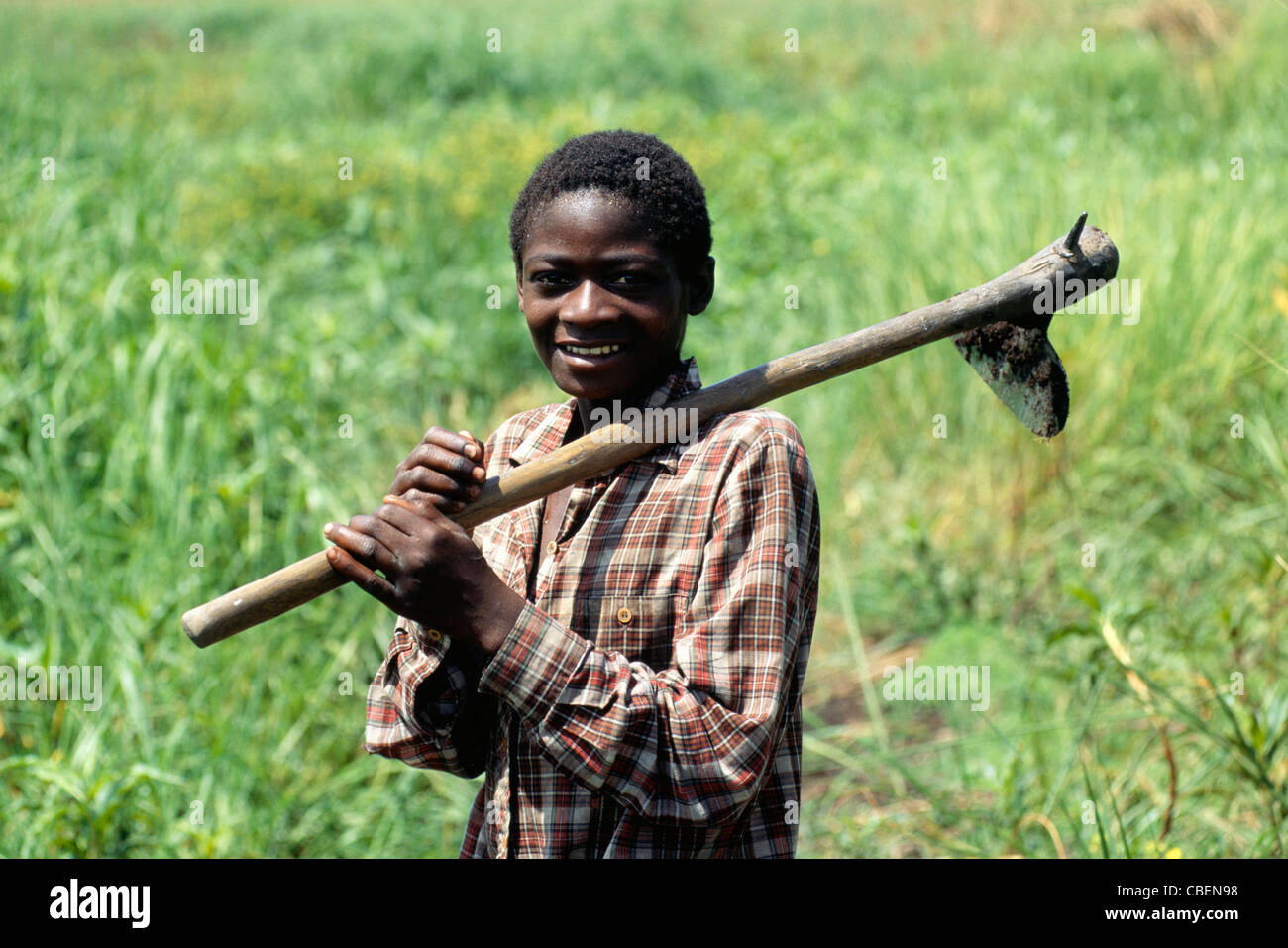 Chipundu, Zambia. Young man carrying an adze to the fields. Stock Photo