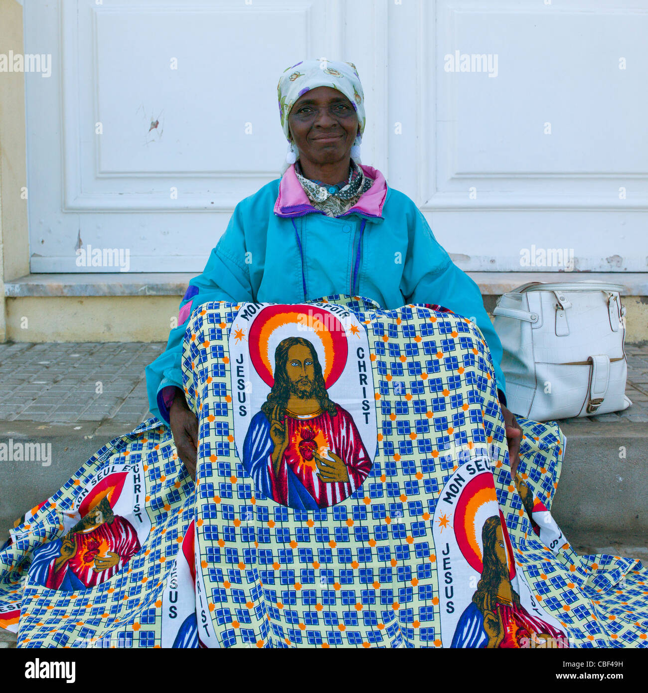 Woman With Headband Selling A Loincloth Decorated With The Head Of Jesus,  Namibe Town, Angola Stock Photo - Alamy