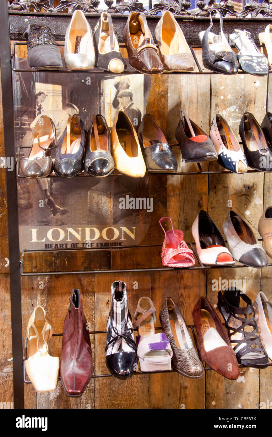 Vintage shoe stall shop display with 'London Heart of the Empire' poster Stables Market Camden Market North London England UK Stock Photo