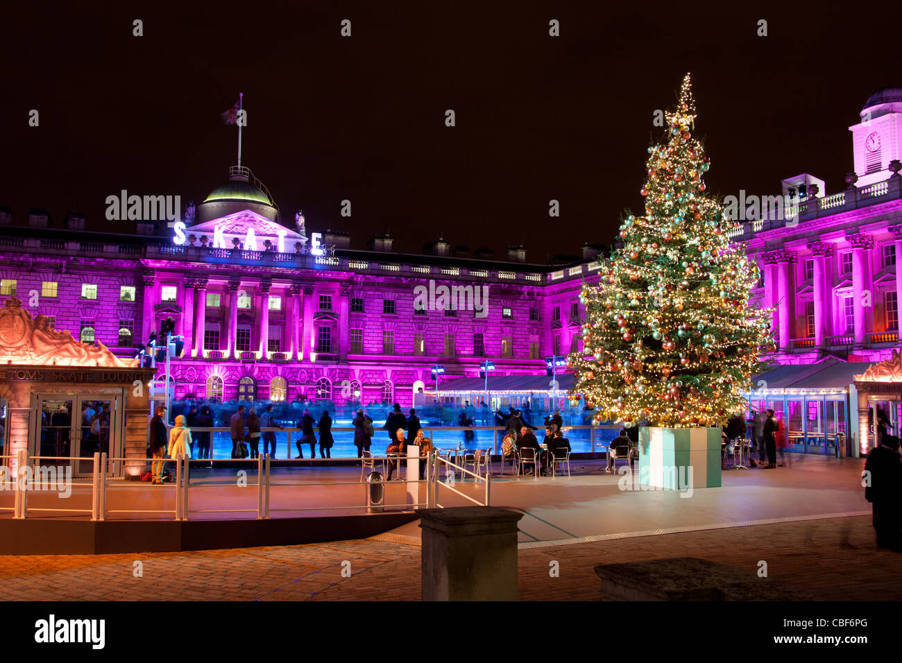 Somerset House Christmas ice rink with tree and people skating at night December 2011 The Strand London England UK Stock Photo