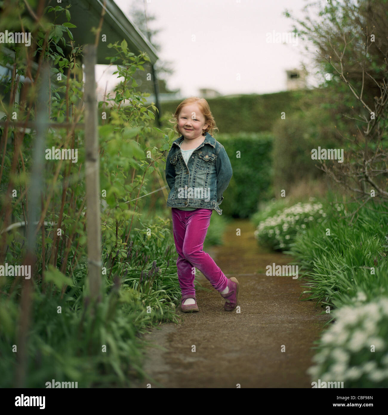 Blonde baby girl standing on patio holding broom Stock Photo - Alamy