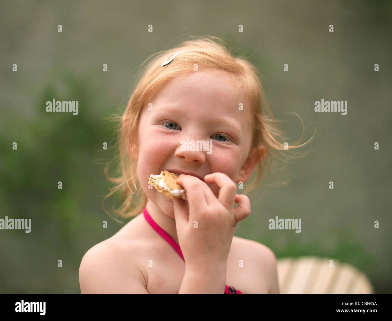 Little girl child eating a sandwich outside Stock Photo