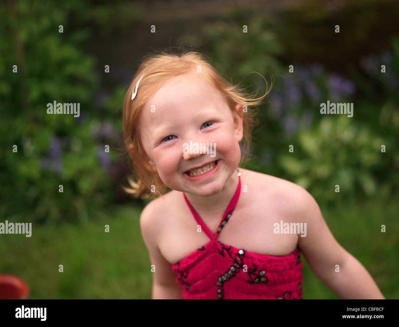 Happy face - little girl smiling and playing in the garden outdoors in summer Stock Photo