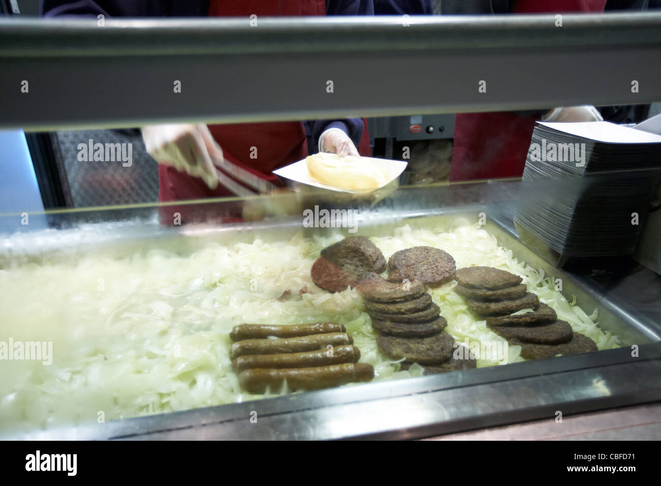 burgers and sausages on bed of onions on a fast food mobile catering van london england united kingdom uk Stock Photo