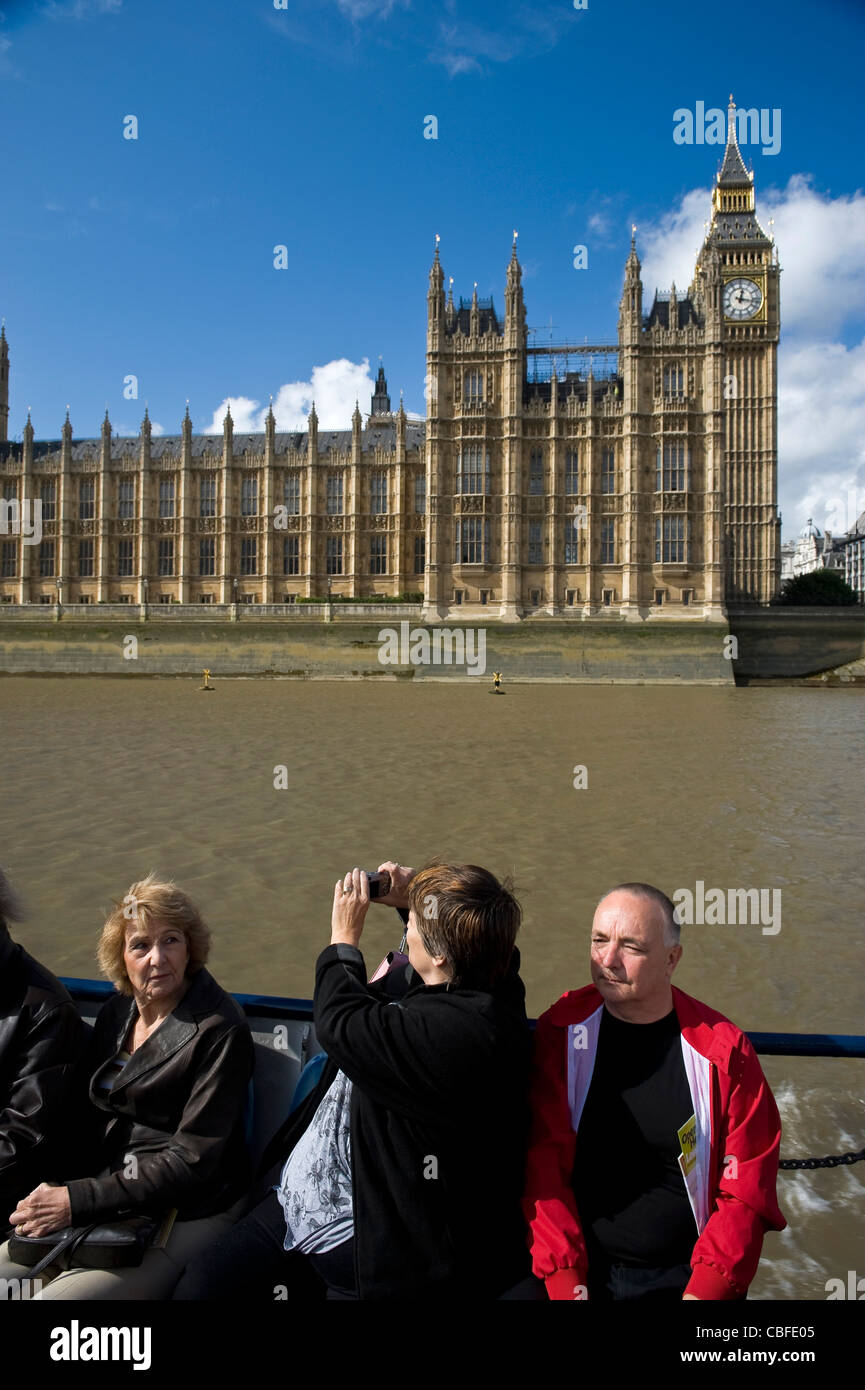People on a Thames River Boat Guided Tour passing the Parliament buildings at Westminster, London, UK Stock Photo