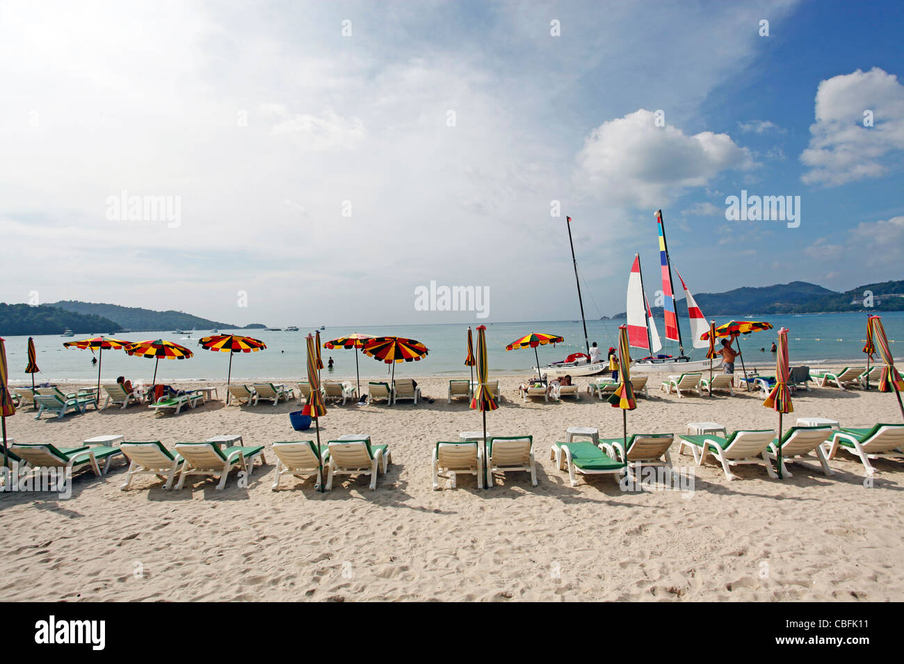 Holiday beach scene with sun loungers and umbrellas on sandy Patong Beach, Patong, Phuket, Thailand Stock Photo