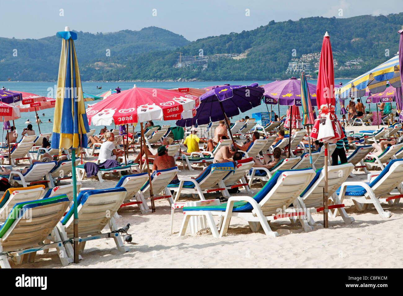Holiday beach scene with sun loungers and umbrellas on sandy Patong Beach, Patong, Phuket, Thailand Stock Photo