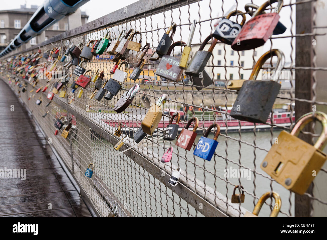 Locks with names of lovers attached to a bridge over the River Vistula, Krakow Stock Photo