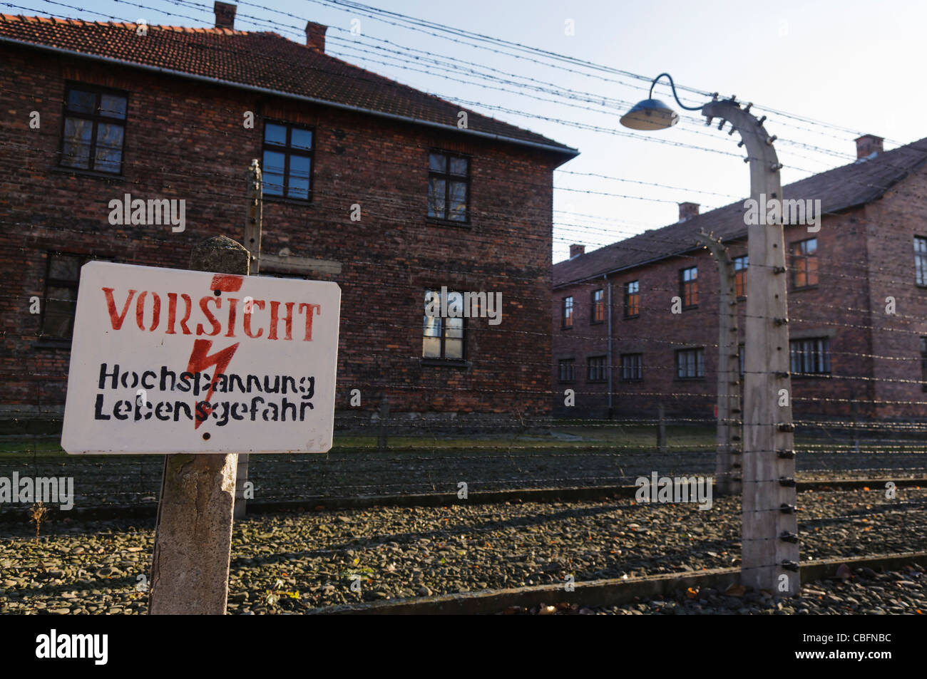 Sign at barbed wire electric fence in Auschwitz 'Vorsicht: hochspannung Lebensgefahr' (Danger: High voltage) Stock Photo