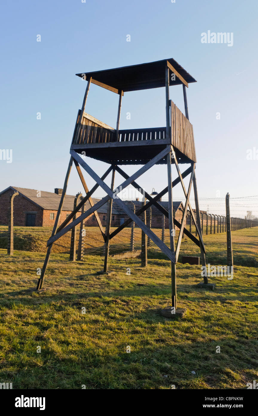 Watchtower beside electrified barbed wire security fence at Auschwitz Berkenau Nazi concentration camp Stock Photo