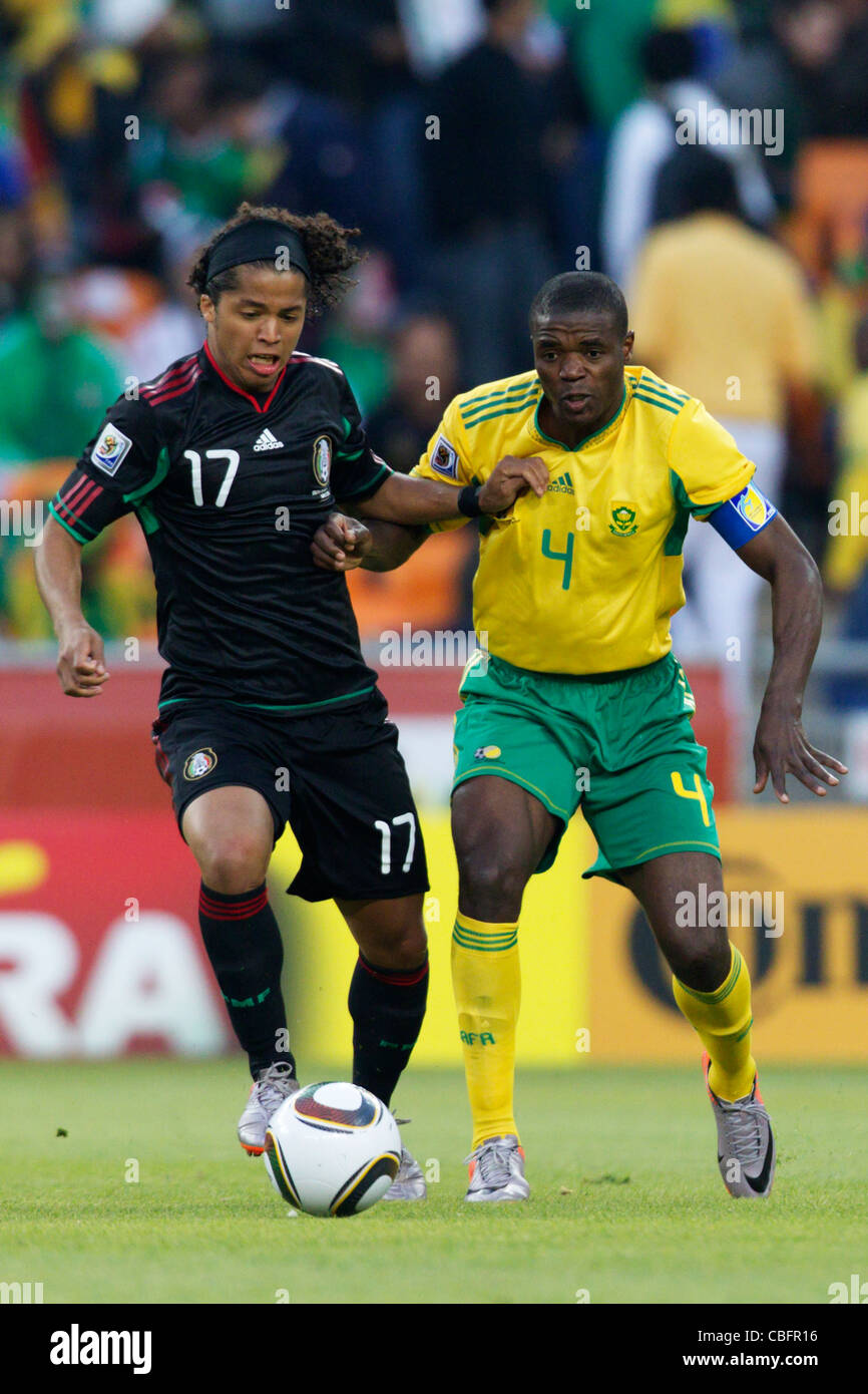 Giovani dos Santos of Mexico (L) battles against South Africa team captain Aaron Mokoena (R) during the 2010 World Cup opener. Stock Photo