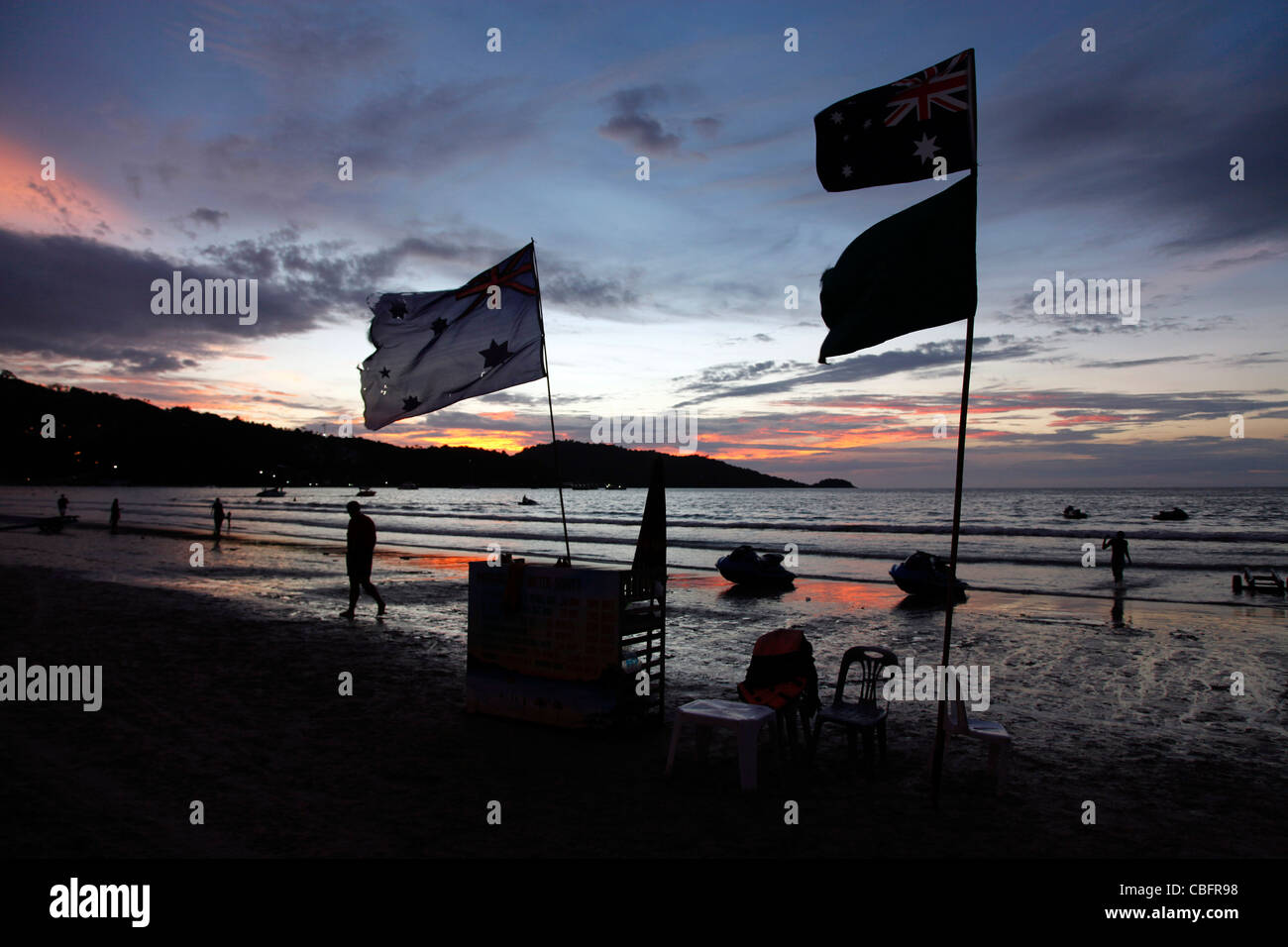 Tropical evening sunset with flags over Patong Beach and the sea in Patong, Phuket, Thailand Stock Photo