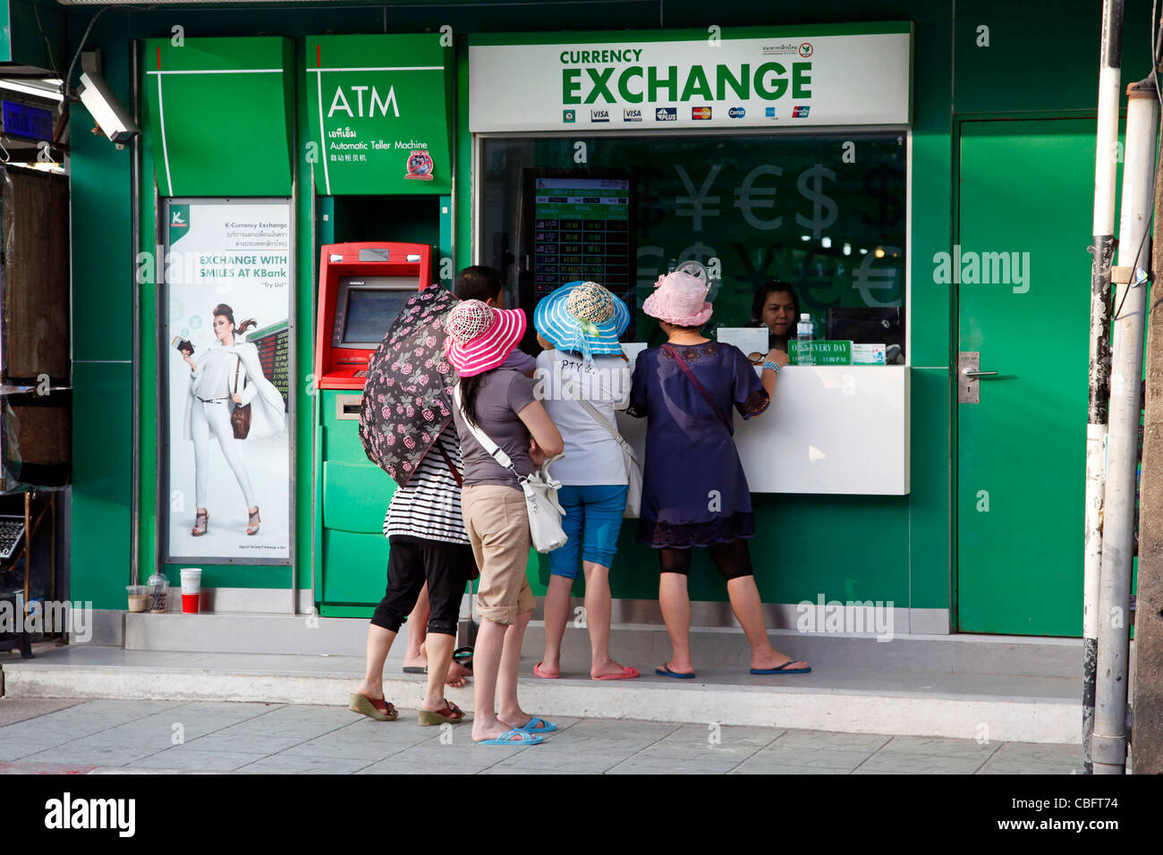 Tourists changing money at a currency exchange booth on Bangla road on Patong Beach in Patong, Phuket, Thailand Stock Photo