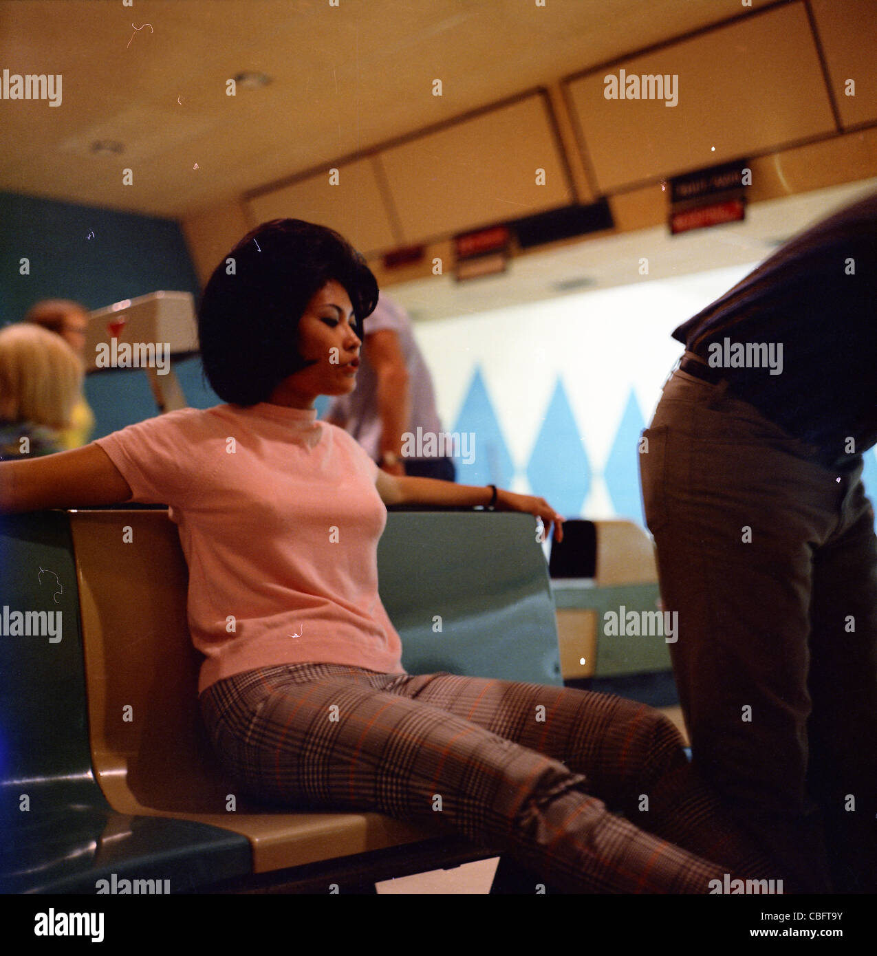 asian woman sitting in chair at bowling alley during 1960s LA southern california Stock Photo