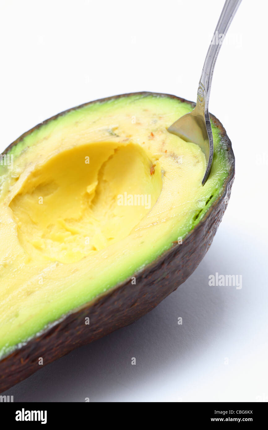 Sliced avocado, complete with spoon ready to eat Stock Photo Alamy