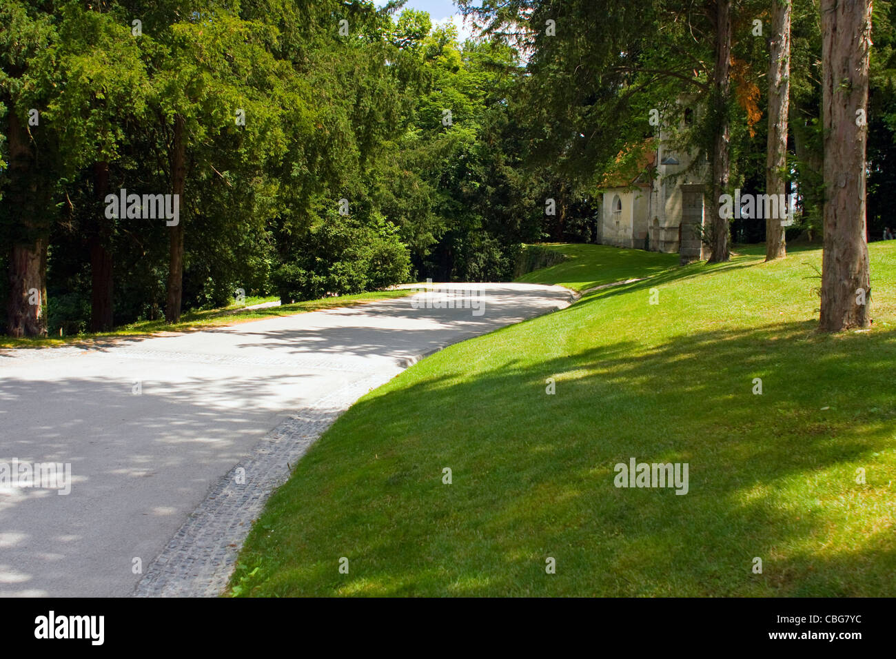 Road in the park with old church in the background. Stock Photo