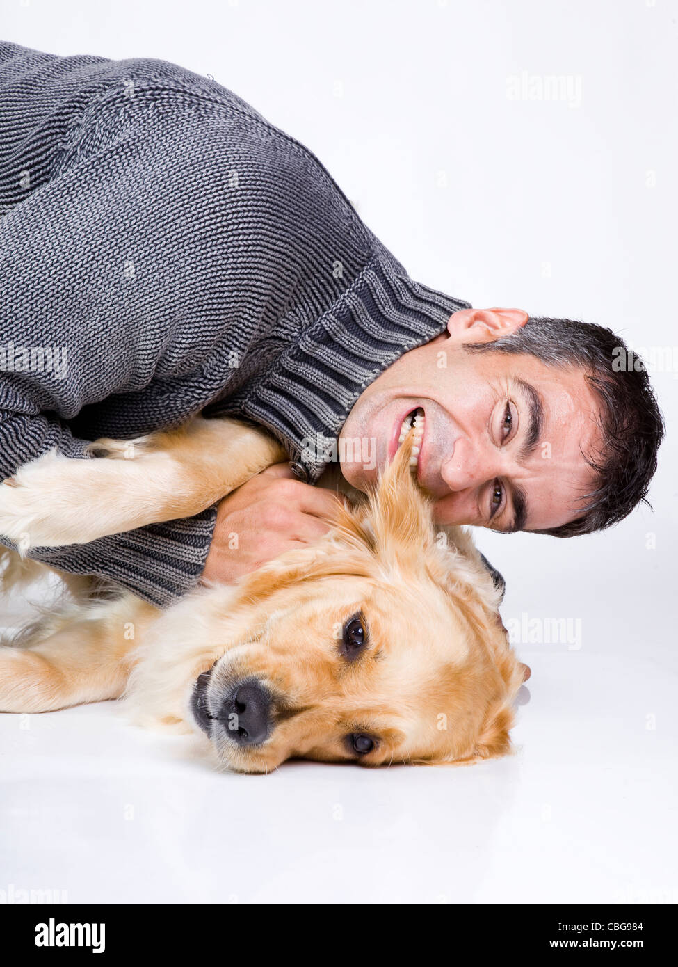attractive man playing with his golden retriever Stock Photo