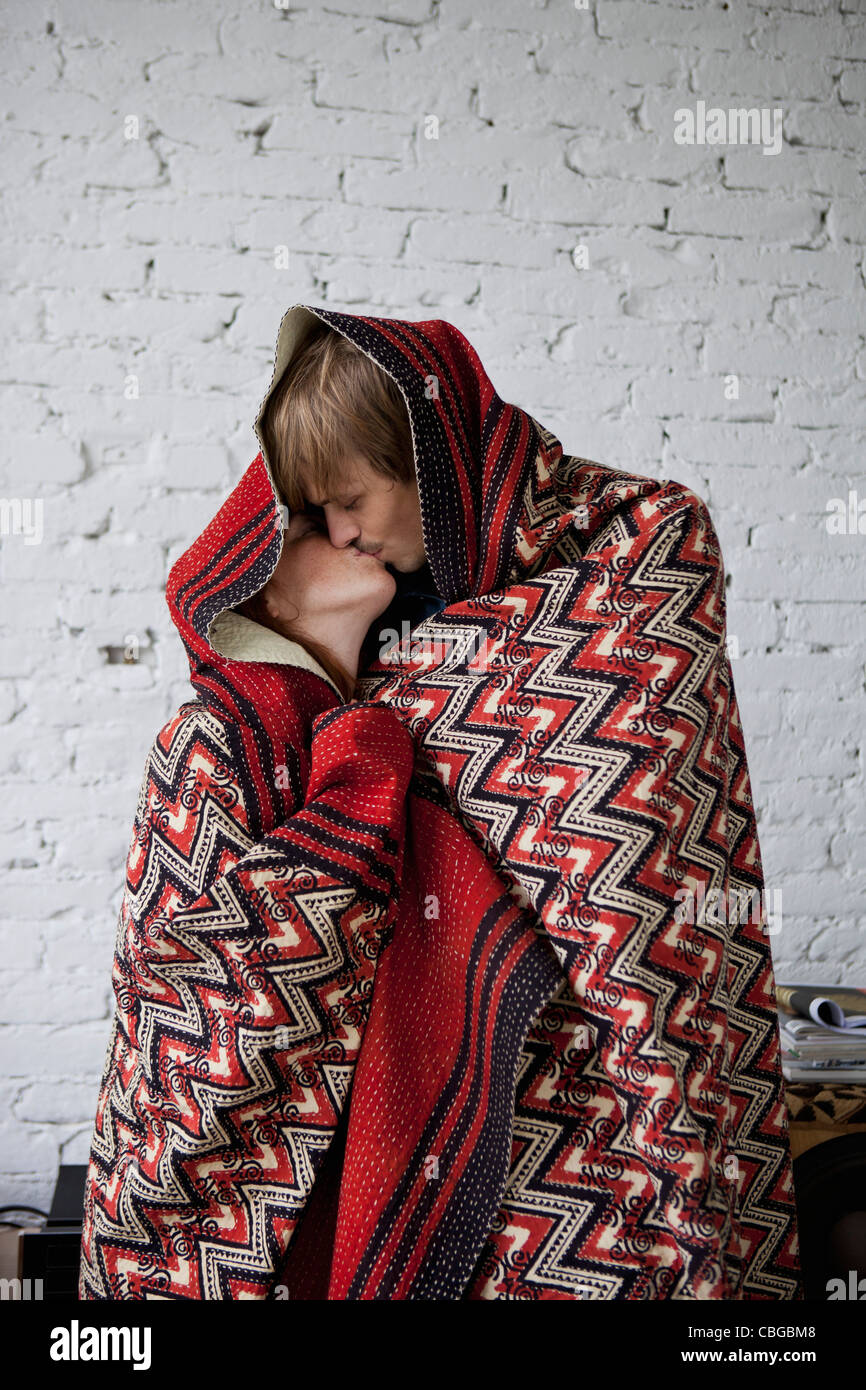 A couple kissing while wrapped in a blanket Stock Photo Alamy