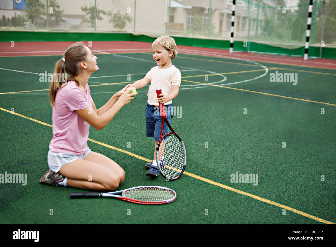 A mother and son having fun on tennis court Stock Photo