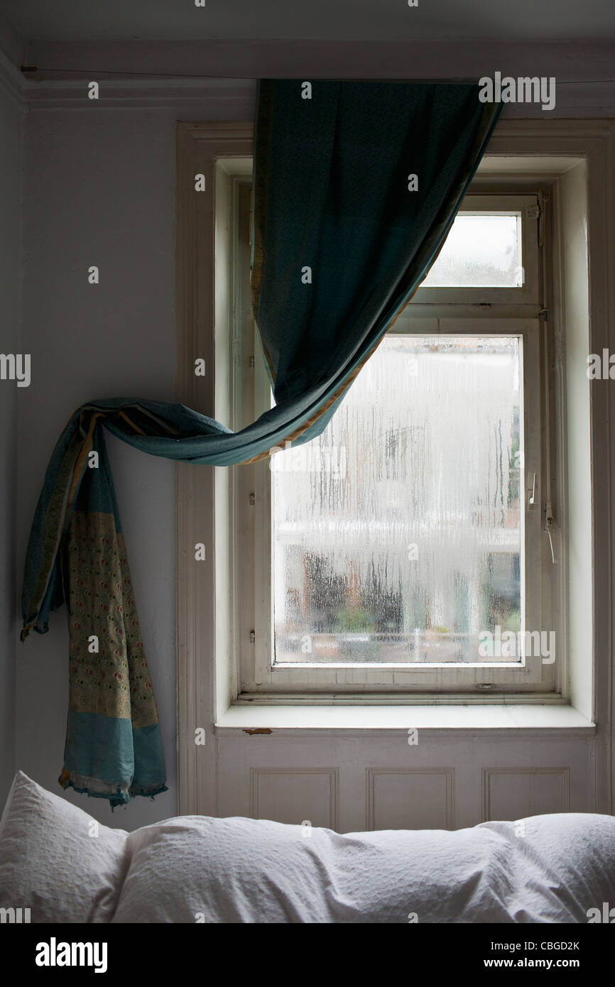 Bedroom showing window and curtain draped to the side Stock Photo