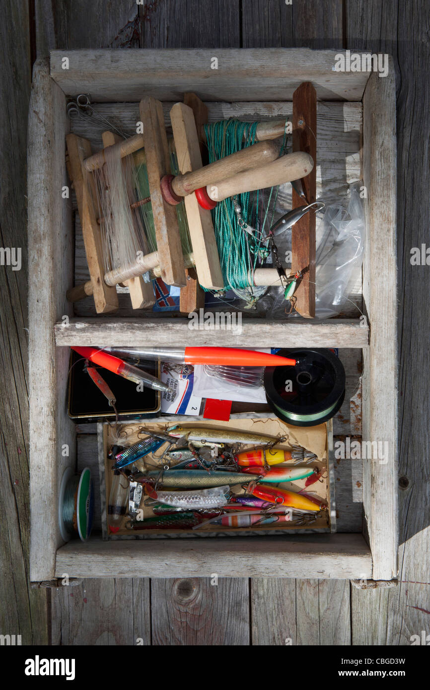 Box of fishing equipment on a background of wood panels Stock Photo