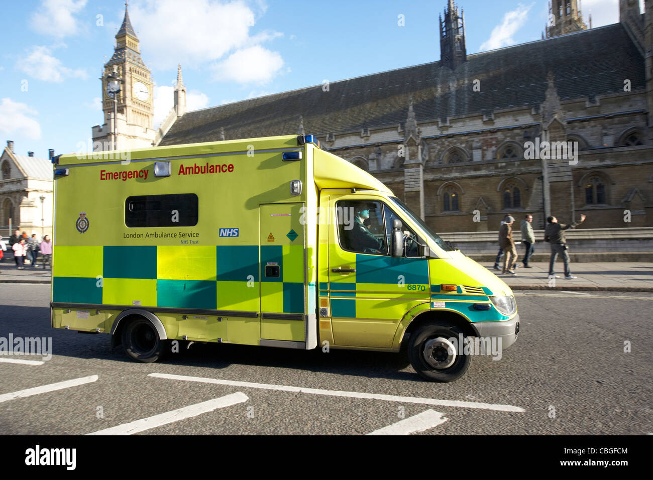 london ambulance service vehicle driving past the houses of parliament england uk united kingdom Stock Photo