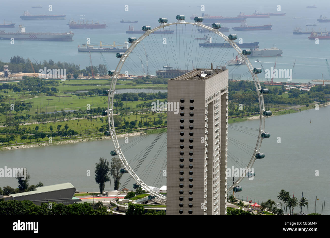 The Singapore Flyer behind the Ritz Carlton hotel, Singapore, high view, aerial with shipping behind. Stock Photo