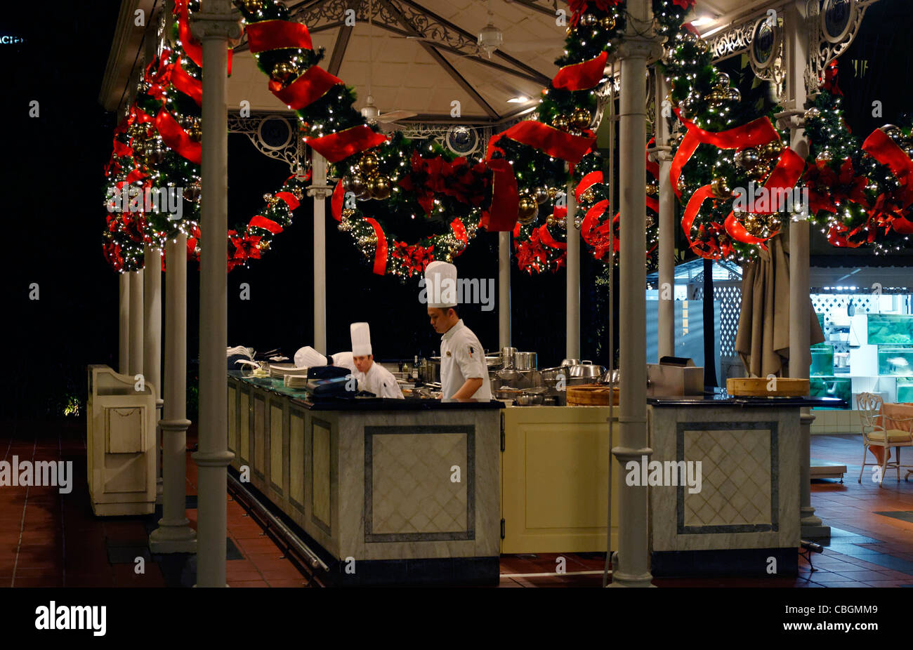 Chef's preparing food in an outdoor kitchen decorated for Christmas at Raffles hotel, Singapore Stock Photo