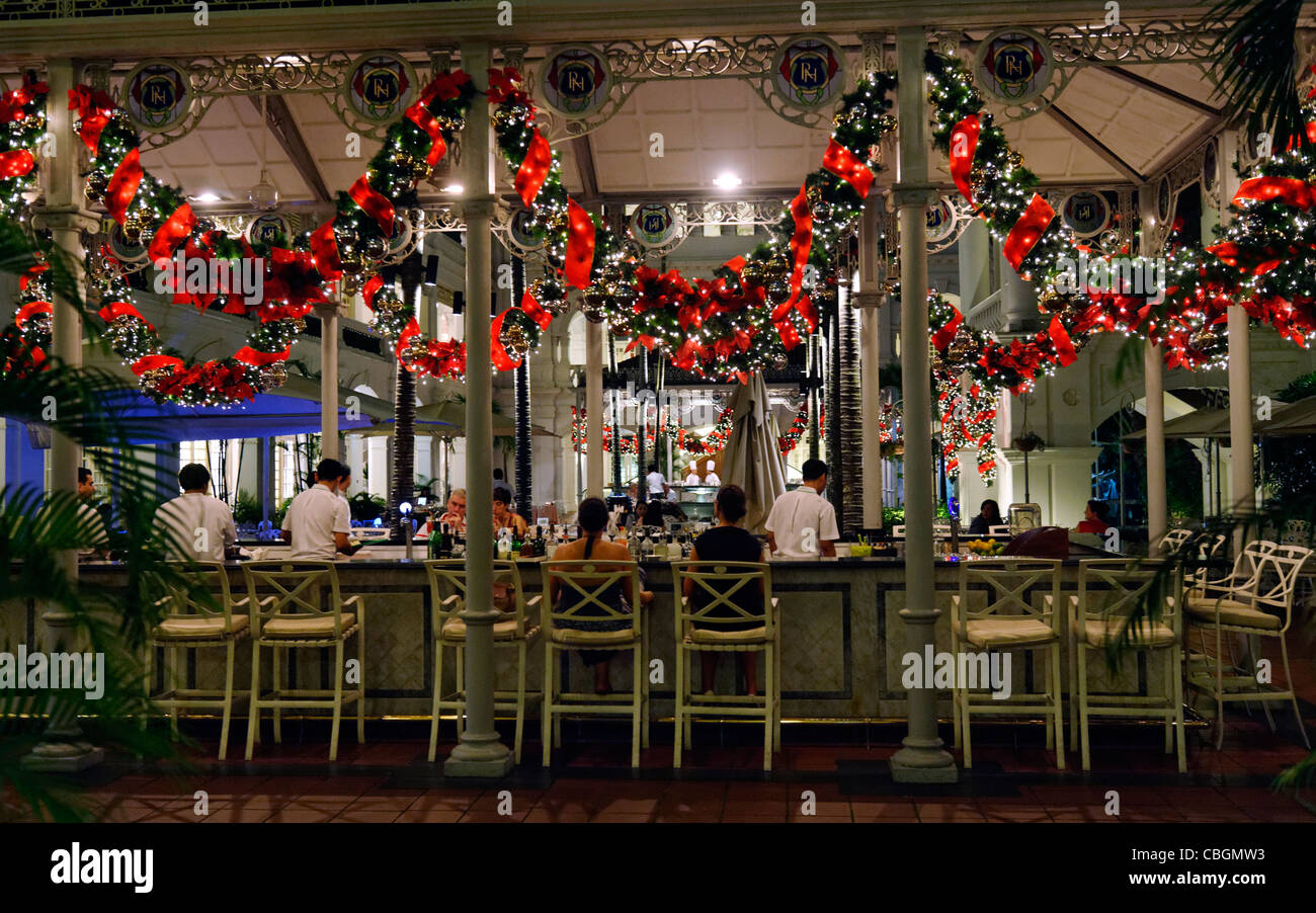 Outdoor drinkers at a bar decorated for Christmas at Raffles hotel, Singapore, Asia Stock Photo