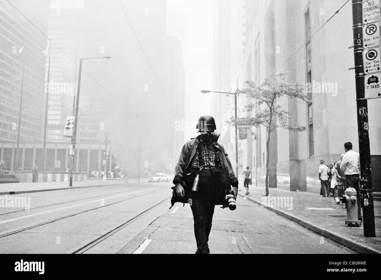 A photographer wearing a gas mask and helmet during a protest at the G20 summit in Toronto. Stock Photo