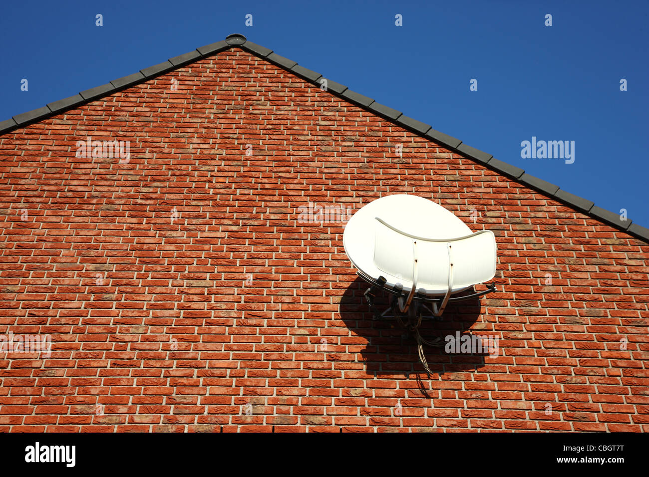 Satellite antenna, dishes, at the wall of a private house, for receiving TV channels, stations. Stock Photo