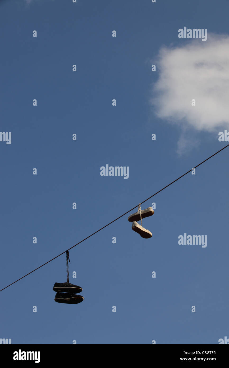 Shoefiti, two pairs of sneakers, trainers dangle from overhead power lines, Greenpoint, Brooklyn, New York City, NYC, USA Stock Photo