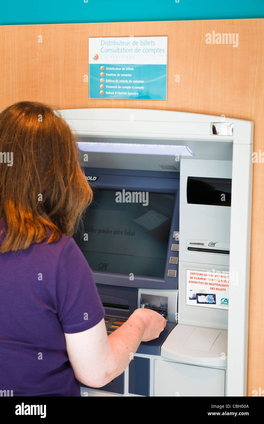 Woman at Credit Agricole cash point, France Stock Photo