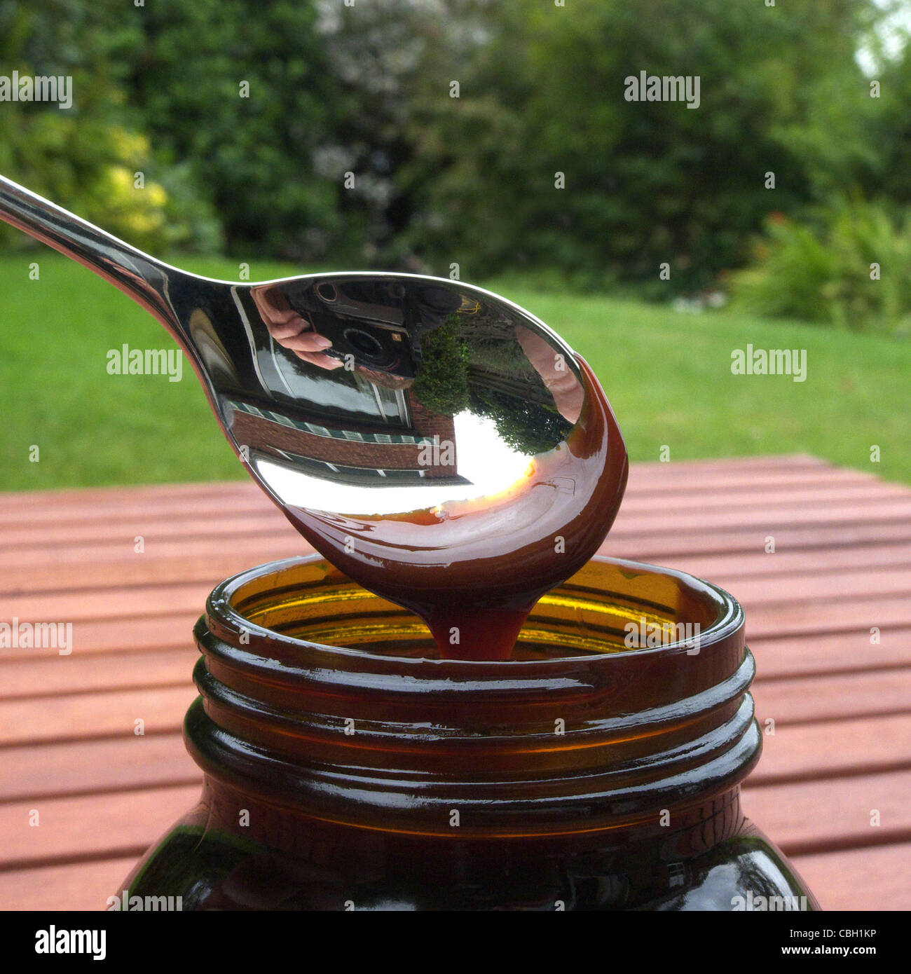 Spooning out Marmite ( Yeast Extract Spread ) from a jar using a teaspoon, UK MODEL RELEASED Stock Photo